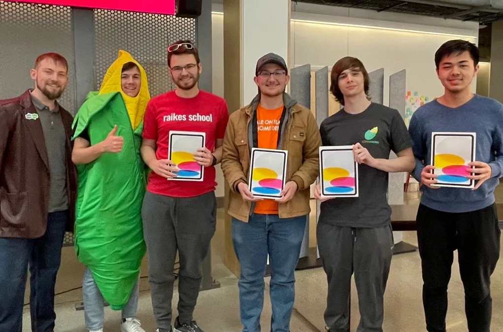 Picture of my hackathon team holding the iPads we won for first place